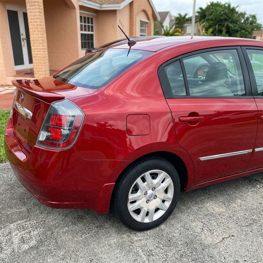 El mismo Nissan Sentra rojo con el costado reconstruido y pintado