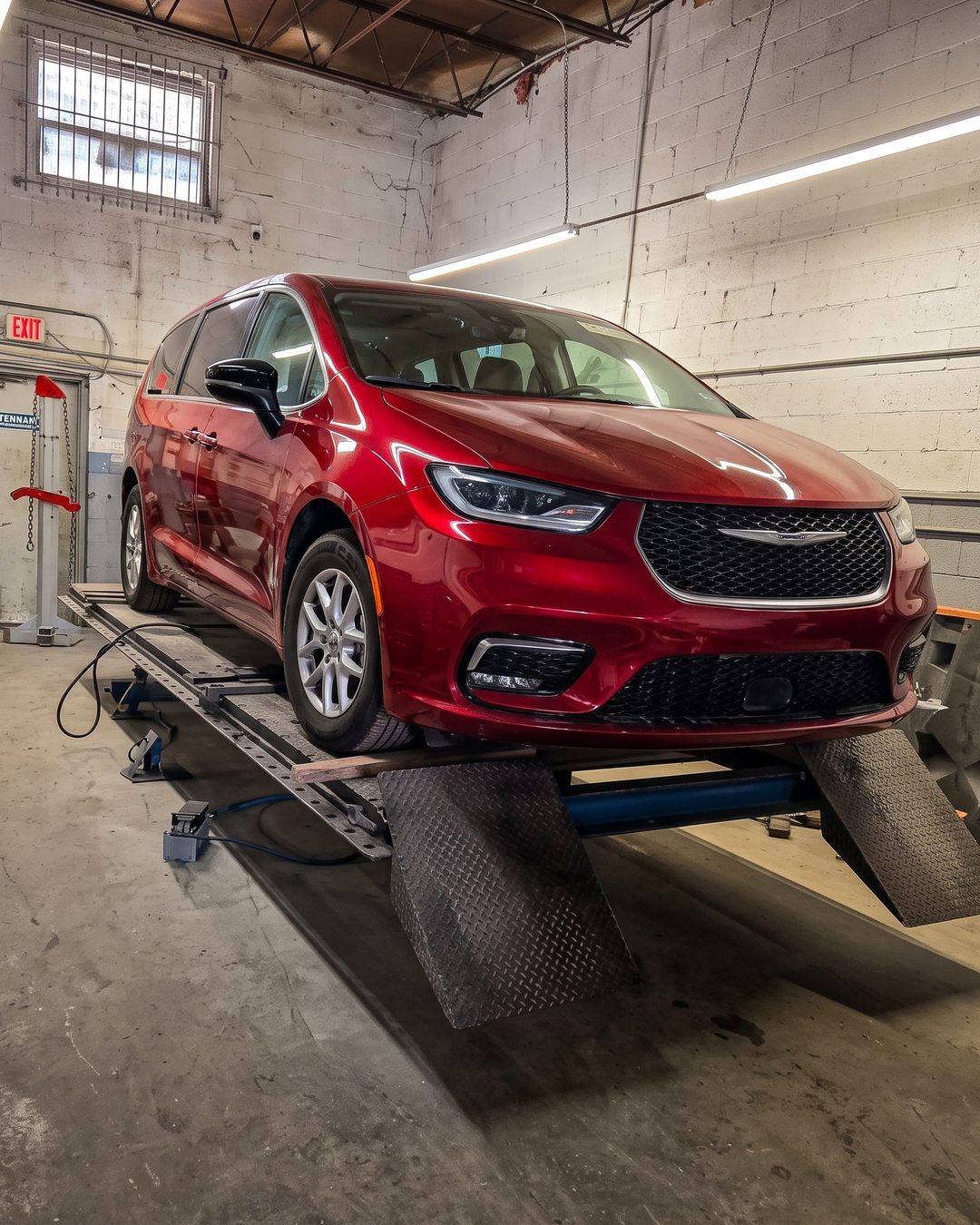 Minivan roja anclada sobre la bancada de estiraje para alinear el chasis
