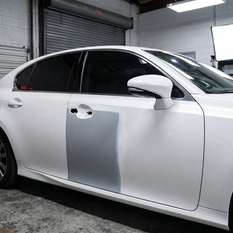 Puerta de un Lexus blanco preparada en primer antes de pintar